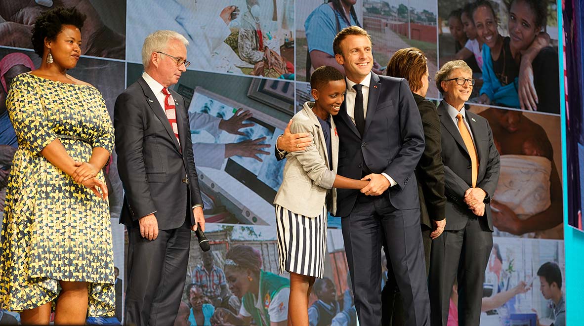 Le Président français Emmanuel Macron donne l’accolade à Amanda Dushime, du Burundi, qui vit avec le VIH, à la clôture de la sixième Conférence de reconstitution des ressources du Fonds mondial à Lyon, en France, le 10 octobre 2019.