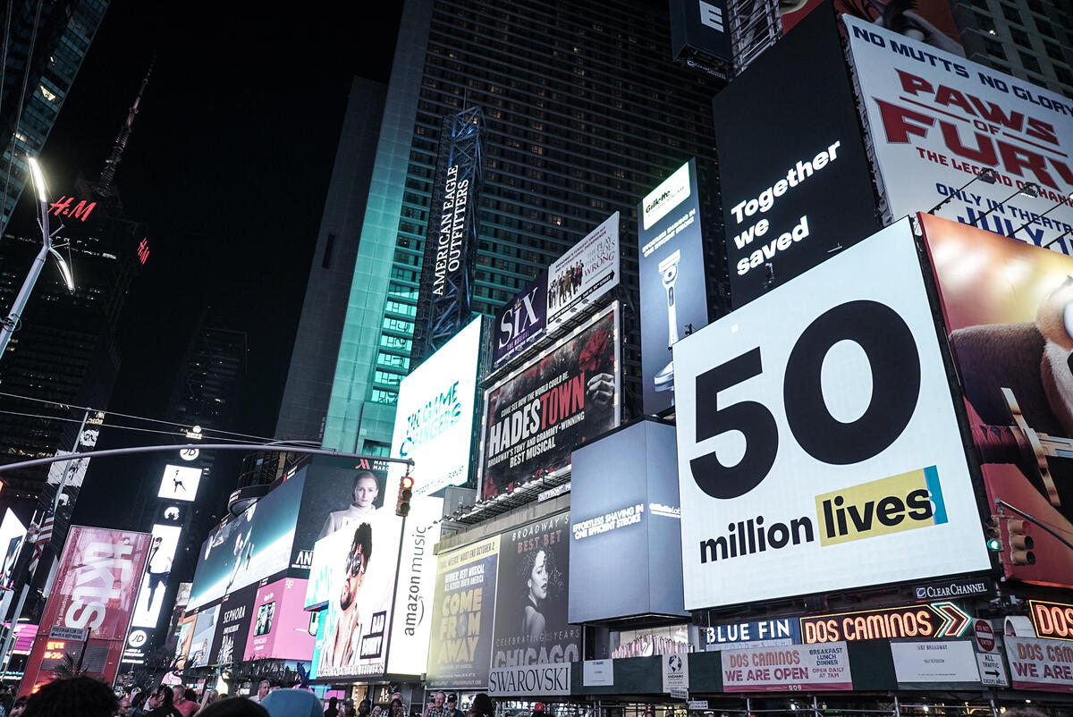 <p>An advertisement at Times Square in New York City reads that the Global Fund partnership has saved 50 million lives since 2002. The Global Fund/Ryan Carpenter</p>