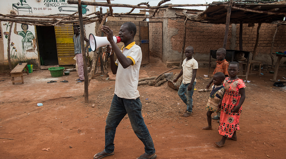 Zongo Ambroise, crieur public depuis 28 ans, transmet des messages sanitaires vitaux à sa communauté dans la ville de Laye, au Burkina Faso. Dans le cadre de la lutte contre le paludisme, il était aux avant-postes de campagnes visant à réduire le nombre de décès d’enfants de moins de 5 ans. Avec l’arrivée du COVID-19, de nombreuses communautés s’appuient désormais sur les agents de santé en première ligne comme Zongo pour savoir comment se protéger du virus.